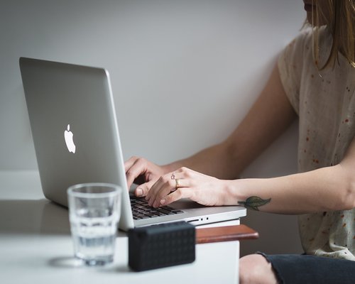 Glass of water near a laptop on a work desk